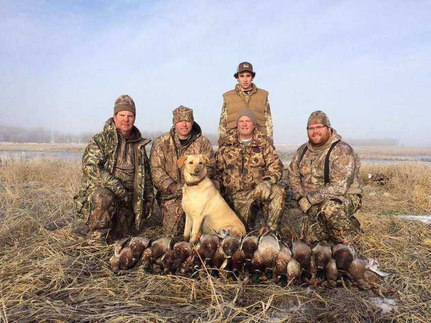 Saskatchewan duck hunt group photo with a yellow Labrador retriever