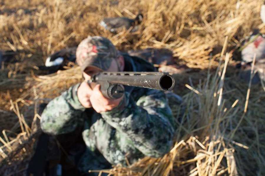 Hunter shouldering a Franchi shotgun in a Tanglefree layout blind on a Prairies Edge Outfitting Saskatchewan waterfowl hunt